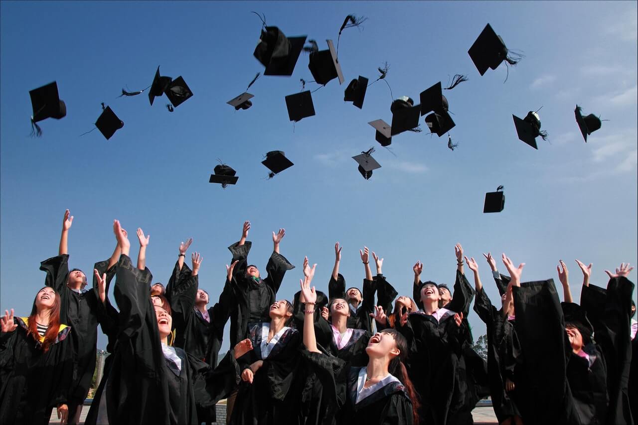 image of graduates tossing their hats